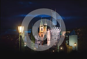 Charles Bridge at night with Lesser Town Bridge Tower and St. Nicholas Church - Prague, Czech Republic