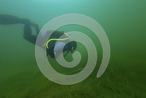 CHARLOTTE, UNITED STATES - Jun 20, 2020: SCUBA diver swimming though fresh water weeds