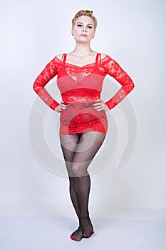 Charming adult blonde girl with short hair and a curvy body posing in a sexy lace blouse and black classic tights pantyhose with a