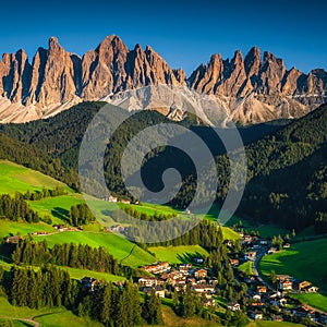 Charming alpine village with green fields and mountains, Dolomites, Italy