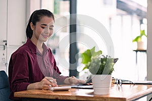 Charming asian female accountant or banker making calculations. Savings, finances and economy concept through a digital