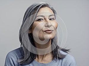 Charming Asian mature woman smiles at camera