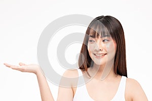 Charming Asian young woman smile with white teeth open hand palm for display cosmetics product