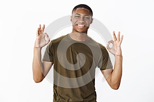 Charming assertive and friendly african american boyfriend showing okay gestures with both hands as assuring everything