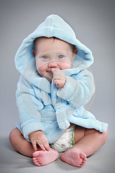Charming baby in a blue bathrobe photo