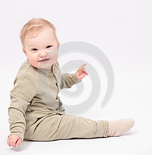 Charming baby sits on the floor and smiles