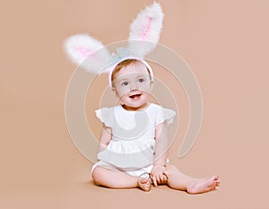 Charming baby sitting in costume easter bunny