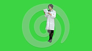 Charming beautiful asian woman doctor hand holds tablets, presenting product on a Green Screen, Chroma Key