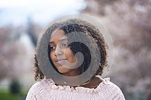 Charming Beautiful Black teen girl with big curly hair. Thinking and being contemplative.