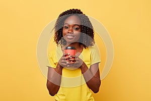 Charming beautiful girl holding takeaway coffee or tea from paper cup