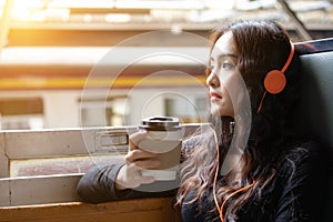 Charming beautiful traveler woman feeling relaxation and happy when gorgeous woman travel in public retro train she listening