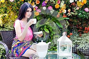 Charming beautiful woman is drinking coffee or tea in afternoon.