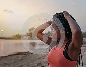 Charming beautiful young african american woman girl with black pigtails with piercings on her face, portrait on the beach at