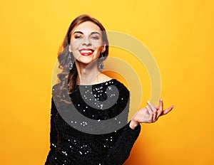 Charming birthday girl in sparkle dress standing in confident pose.