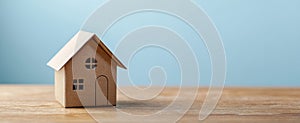 The charming cardboard house model on a wooden table against a serene backdrop. AI generated image