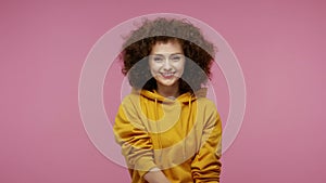 Charming carefree girl afro hairstyle in hoodie sending air kisses to camera, demonstrating love affection fondness