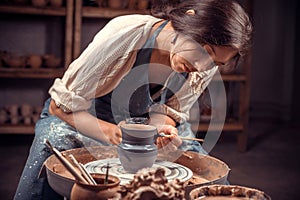 Charming ceramist working with pottery at the ceramic workshop. Handmade products.