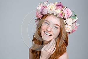 Charming cheerful woman with red hair in beautiful flower wreath