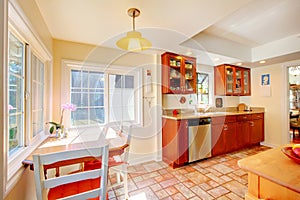 Charming cherry wood kitchen with tile floor.