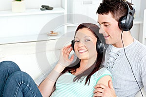 Charming couple listening to music with headphones