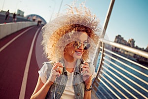 Charming curly blonde music lover. Young woman with big headphones.