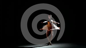 Charming curly girl dancing ballet in studio