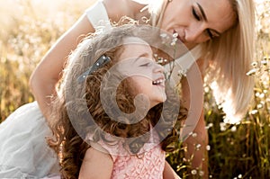 Charming curly-haired babe laughs with mom