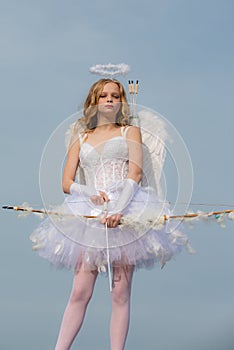 Charming curly little girl in white dress and wings - angel cupid girl. Child with angelic character - Valentine concept