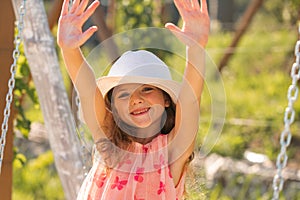 Charming cute caucasian little girl wearingstraw hat standing outdoors. Funny kids face. Summer vacation and happy