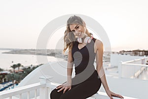 Charming cute young woman in sportswear enjoying sunrise on seafront, smiling to camera Outwork, sportive lifestyle photo