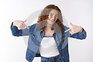 Charming energized carefree ginger girl freckles acne prone skin vegan wearing denim jacket having fun pointing index