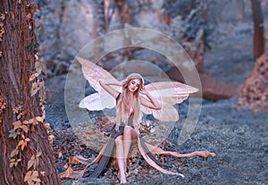Charming fairy woke up in forest, sweetly smacks after sleeping, cue girl with blond hair, eyes closed in long green photo
