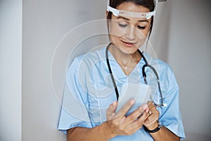 Charming female doctor using mobile phone in clinic