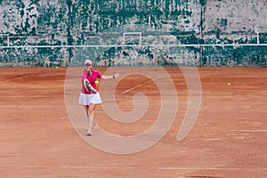 Charming female tennis player taking receive serve. Dressed in stylish sportswear. Outdoors