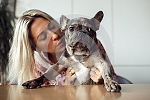 Charming French bulldog listens attentively to what his owner says in his ear. Healthy pets. Happy moments. Positive.