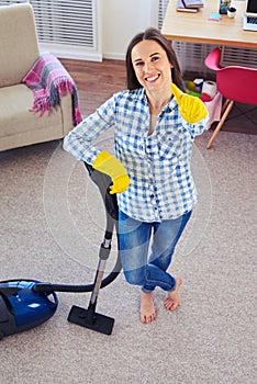 Charming girl holding vacuum cleaner and showing clearness of ca