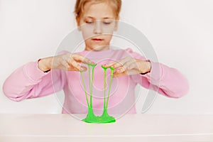 A charming girl holds a hand-made toy called slime