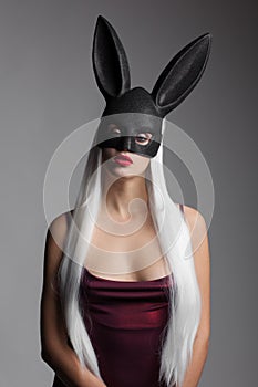 The charming girl with long straight white hair and black rabbit mask on her head