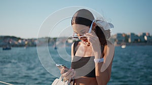 Charming girl looking smartphone screen at sunny seaside close up. Happy woman