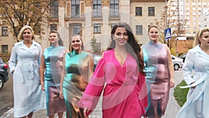 Charming girls in beautiful dresses defile on the street. Plus size Fashion Week. Slow motion.