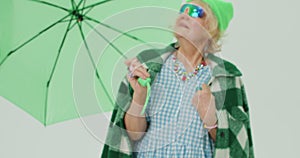 charming glamour senior woman in fashoinable outfit spinning green umbrella