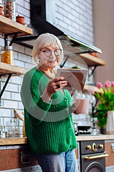 Charming granny feasting eyes with grandchildren picture in frame