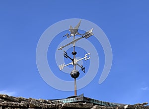 Charming heron weathervane on the roof on a sunny day