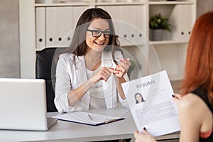 Charming HR manager in friendly manner leads a job interview with one of the candidates on post. Selective focus