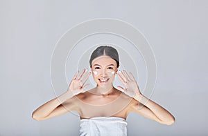 Charming joyful Asian woman applies anti-wrinkle cream