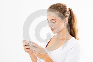 Charming joyful girl is reading pleasant text message on mobile phone from her boyfriend during her rest time. Smiling