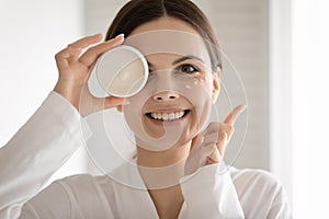 Charming lady advertizing new line of cosmetics looking at camera photo