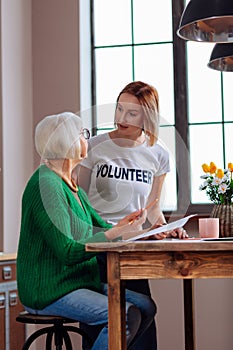 Charming lady having discussion with young-adult girl about documents