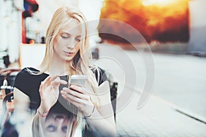 Charming lady with smart phone in street bar