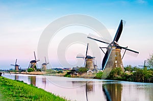 The charming landscape with windmills in Kinderdijk, Netherlands, Europe against a background of cloudy sky reflection in the